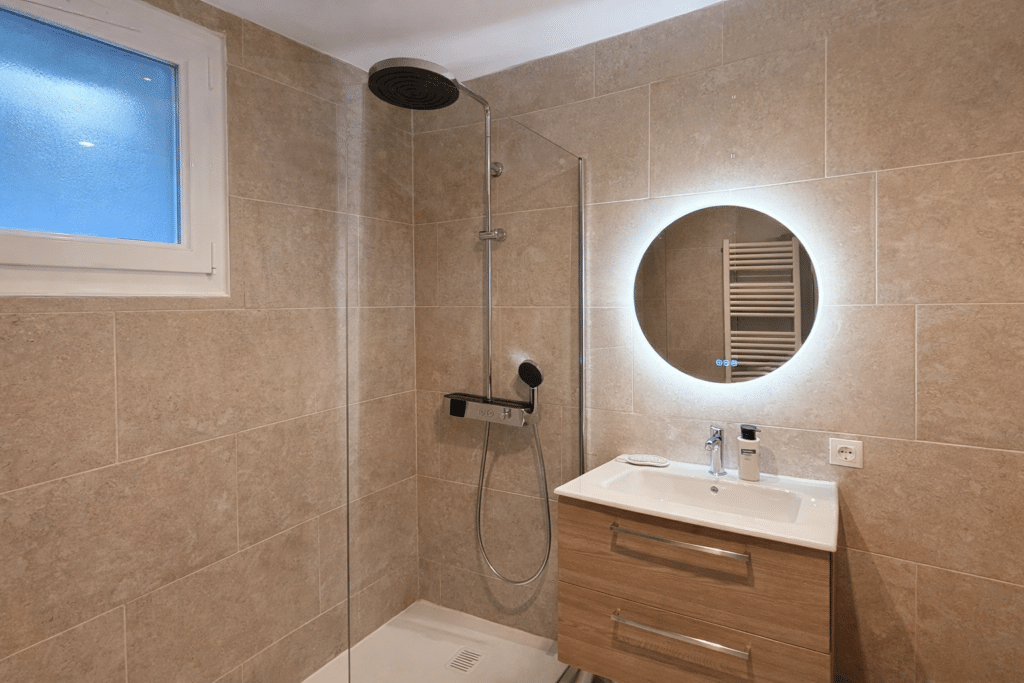 Salle d’eau en longueur : pierre douce & bois clair