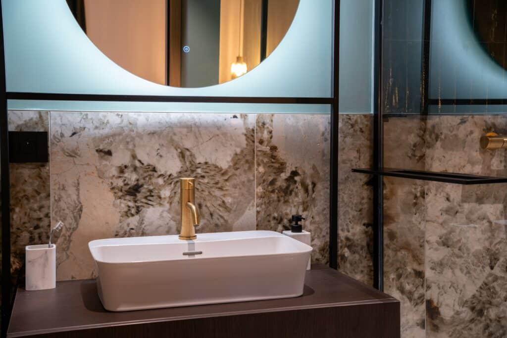 Salle de bain minérale : vert profond & touches laiton